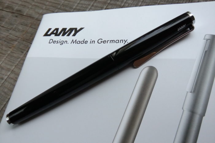 перьевая ручка LAMY Studio Piano Black на фоне каталога с ручками LAMY
